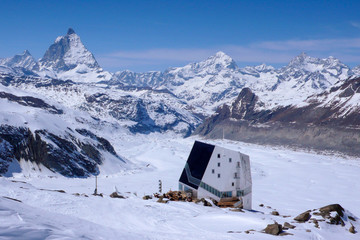 horizontal view of the Monte Rosa mountain hut with the famous Matterhorn peak and surrounding winter landscape in the background