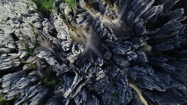 Overhead drone shot of tourists trying to navigate Shilin Stone Forest, labyrinth like maze of limestone pillars in popular national park in Yunnan, China