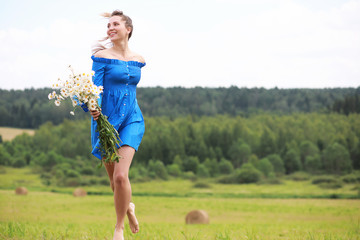 Young cute girl run in a field at sunset