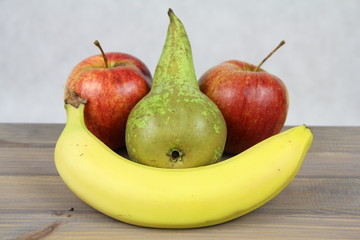 Owocowa buźka - jabłka gruszka i banan ułożone w zadowoloną minę
