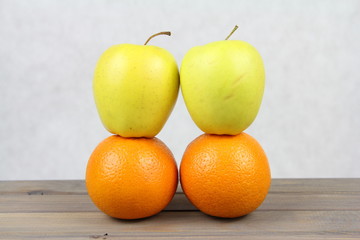 Owoce - pomarańcze i jabłka ustawine jeden na drugim