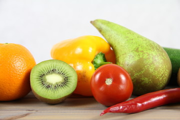 Zdrowa żywność - owoce i warzywa na drwenianej podstawie i jasnym tle