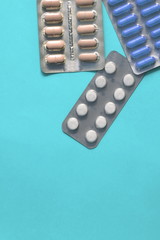 Blisters of different pills on blue background. Copy space for text