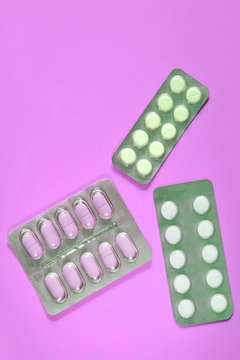 Blisters of different pills on purple background. Copy space for text