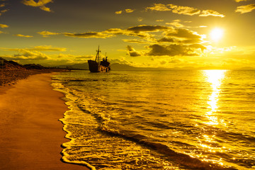 Rusty broken shipwreck on sea shore