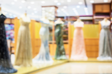 Blurred image of a boutique shop window with mannequins in fashionable dresses for the background.