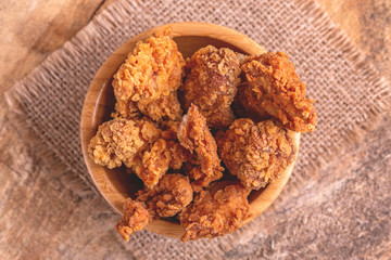 Delicious breaded chicken nuggets in wooden bowl on burlap napkin