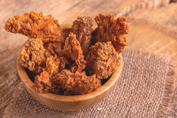 Delicious breaded chicken nuggets in wooden bowl on burlap napkin