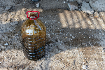 Old black car oil is poured into containers for further processing.