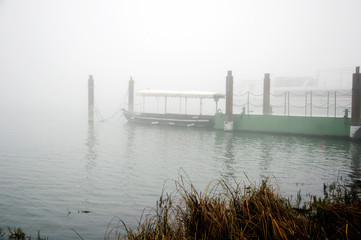 pleasure boat on the pier, foggy autumn morning