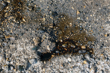 ]Old black car oil spilled on the ground.