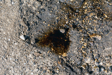 ]Old black car oil spilled on the ground.