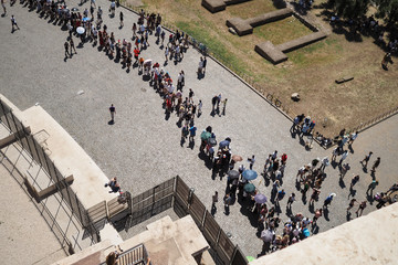 Aerial view from the Colosseum of toursists queuing on a hot day in Rome, Italy, holding parasols and umbrellas