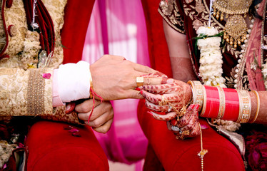 Bride putting a wedding ring on groom's finger