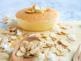 Fototapeta na wymiar One piece of mini cheese cake with almond on top on wood tray for menu or bakery business.