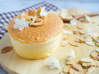 Obraz na płótnie Canvas One piece of mini cheese cake with almond on top on wood tray for menu or bakery business.