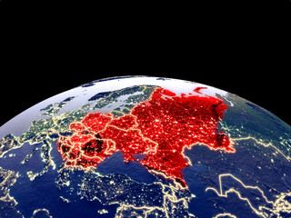 Eastern Europe from space on planet Earth at night with bright city lights. Detailed plastic planet surface with real mountains.
