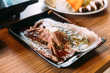 Touched medium rare sliced authentic A5 Grade Japanese Wagyu beef sushi topping with fresh garlic. 