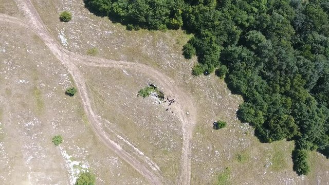 Aerial view of the cave entrance of the mountain people down rope, mountains Karaby Yayla, beautiful green forest pine woods and nature scape mountain with sun flare in summer day Crimea.
