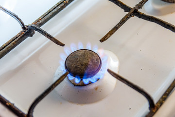 Gas burner on the white kitchen stove
