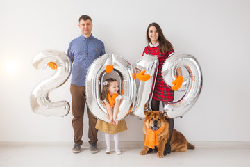New 2019 Year is coming concept - Happy family with dog are holding silver colored numbers indoors.