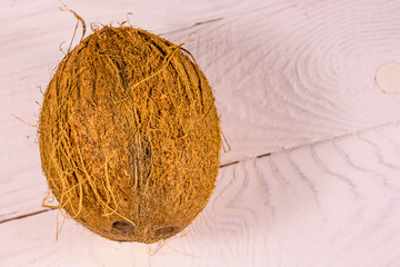 One whole coconut on a wooden table. Top view