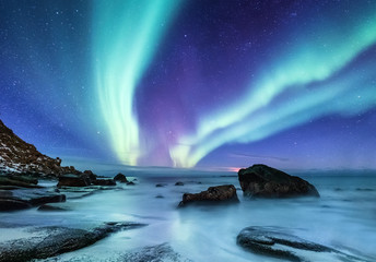 Aurora borealis auf den Lofoten, Norwegen. Nachthimmel mit Polarlichtern. Nachtwinterlandschaft mit Aurora und Reflexion auf der Wasseroberfläche. Natürlicher Hintergrund in Norwegen