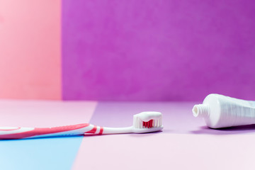 toothbrushes and a toothpaste on a colorful background