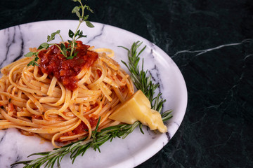Delicious spaghetti served with parmesan cheese on a marble plate