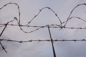 Barbwire silhouette with a cloudy background a gloomy sky and gloomy day 