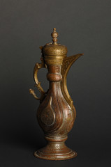 ancient oriental metal teapot on dark background. antique bronze tableware