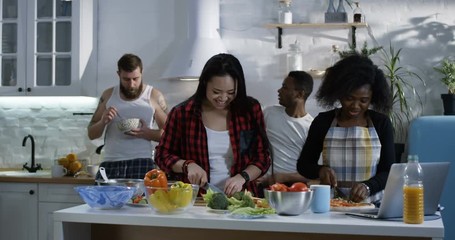 Medium shot of group of people preparing food in the kitchen