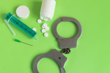 Drugs and handcuffs composition. Crime concept.