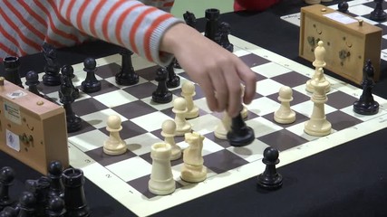 FOCUSING CHILD’S HAND PLAYING CHESS