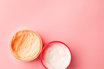 cosmetic for body, face, hair. face cream in a jar. hair mask. skin care. on a pink background. selective focus.