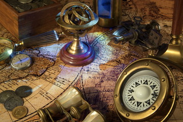 Fototapeta na wymiar Old Zodiac globe,astrological.Vintage map,old coins.Retro ship lantern,binoculars,sextant.Antique compass.Candlestick,watch and magnifier Travel and marine engraving background. Treasure hood concept.