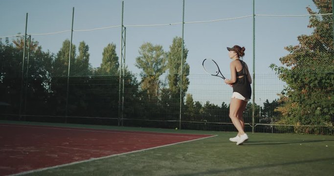 At tennis court outside professional are playing a sportiv woman tennis game.