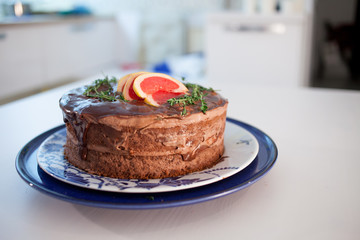 Chocolate cake poured with chocolate and decorated with grapefruit slices