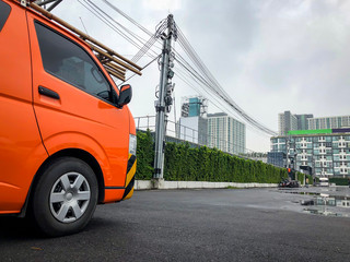 Private company electric orange van parking at the outdoor parking waiting for electric services.