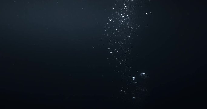 4K underwater illuminated bubbles motion. Ocean floor bubbles. Real underwater footage. Deep under sea level. Floating plankton. Marine background VFX element. Underwater bubbles mayhem