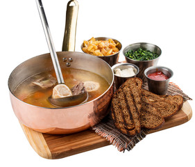 Tafelspitz. Veal soup with the bone and garnish. Austrian cuisine. On white background.