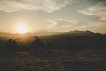 Obraz premium abstract morning sun rise unfocused scenic landscape with valley and mountain background horizon silhouettes 