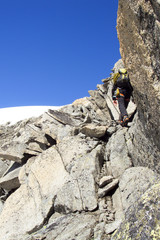 male mountain climber on an and exposed rock face on his way to Eiger mountain in the Swiss Alps near Grindelwald
