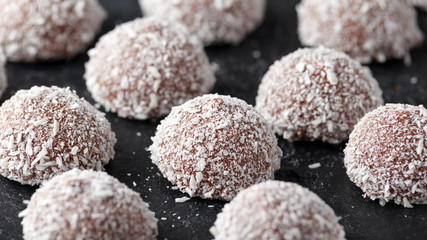 Fototapeta na wymiar sweet mallow snowballs with chocolate coating and coconut