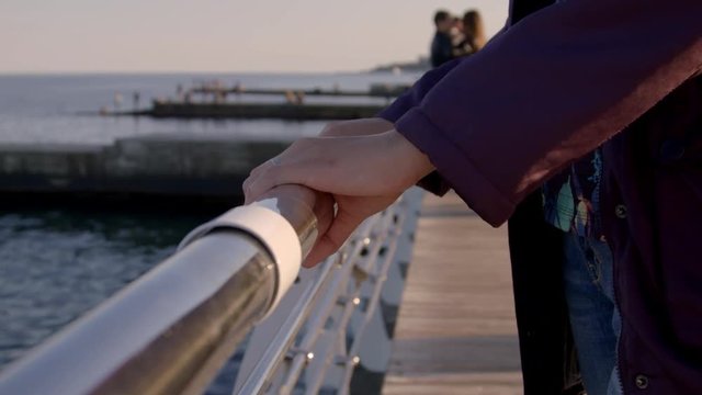 4K Close-up shot of hand touching railing near the sea