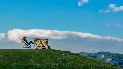 young woman thinking and looking at the city from a mountain