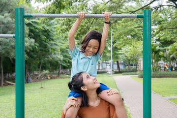 Obraz premium Woman and daughter play with a horizontal bar