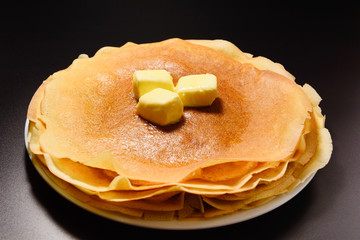 Fresh golden delicious pancakes with butter. The concept of homemade food.