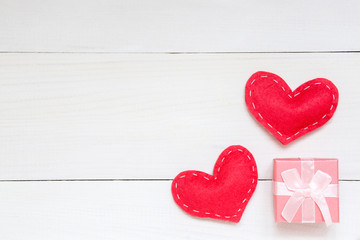Red hearts and gift on white wooden background for Valentines day, copy space, top view.