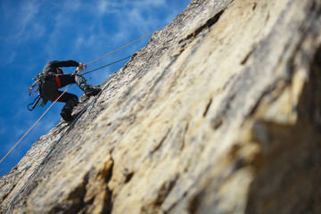 The climber is hanging on a safety rope on a rock wall.